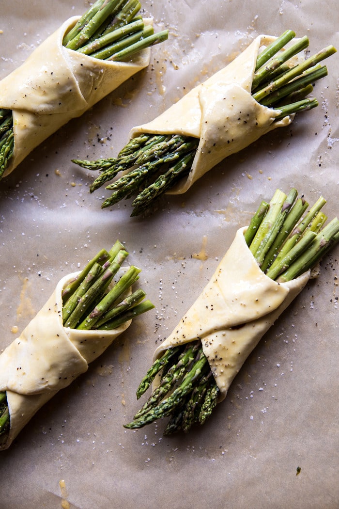 overhead prep photo of asparagus and brie pastry wrapped up and brushed with egg