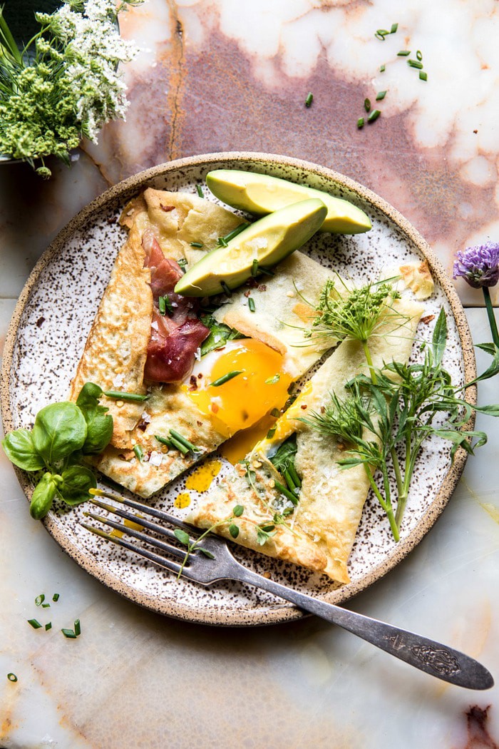 overhead photo of cut into Baked Egg Crepes with Spring Herbs and Avocado