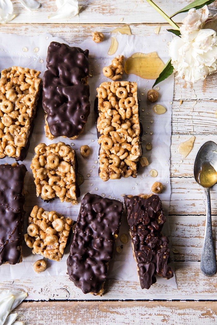 overhead photo of Chocolate Dipped Peanut Butter and Honey Cheerio Bars with honey spoon