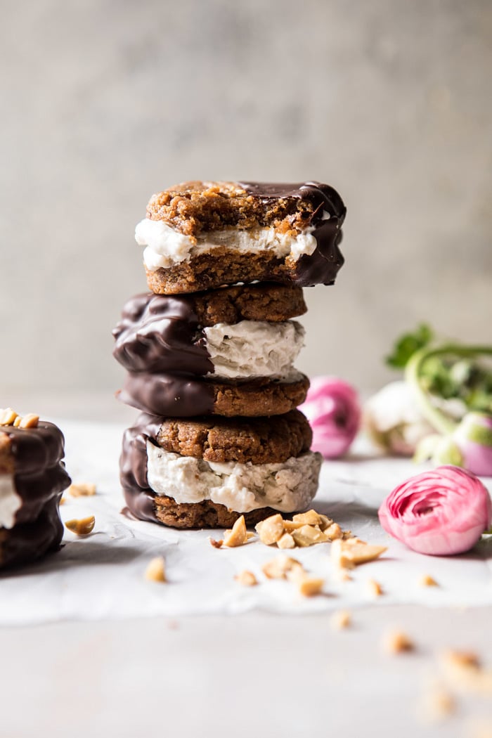 stacked front on photo of Chocolate Dipped Peanut Cookie Ice Cream Sandwiches with bite out of sandwich