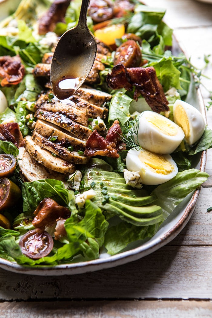 side angled photo Balsamic Grilled Chicken Cobb Salad with spoon and dressing