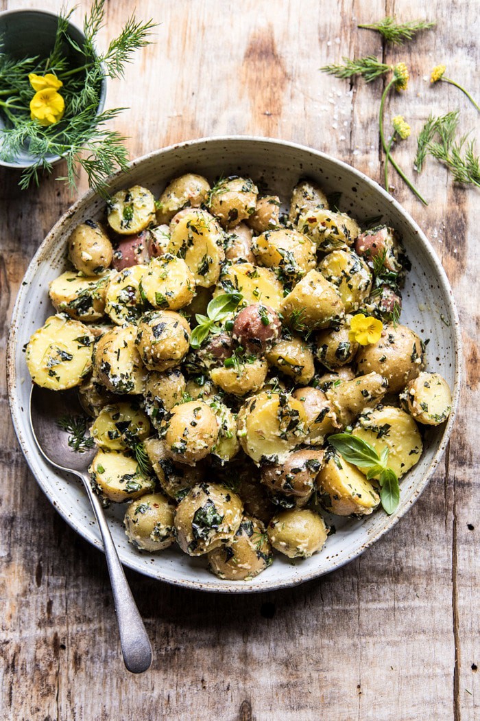 overhead photo The Best Herby Potato Salad with bowl of herbs