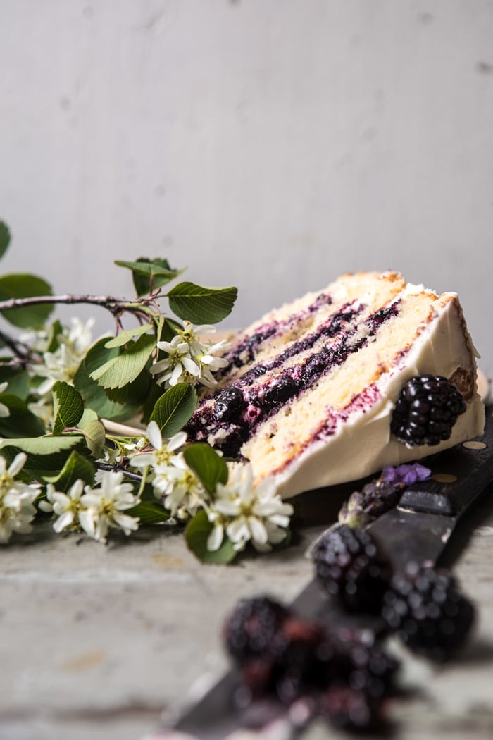 side angled photo of Blackberry Lavender Naked Cake with White Chocolate Buttercream with one slice