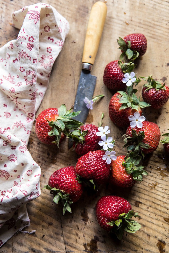 overhead photo of strawberries with flowers and pairing knife 