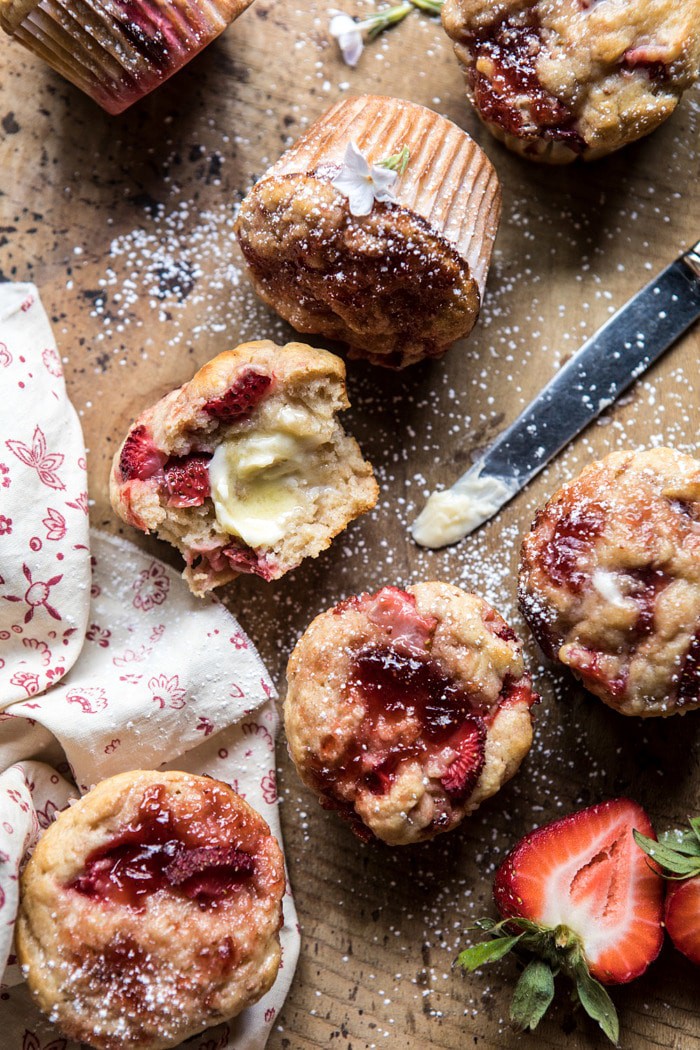 overhead photo of half eaten Honey Strawberry Muffins with melting butter