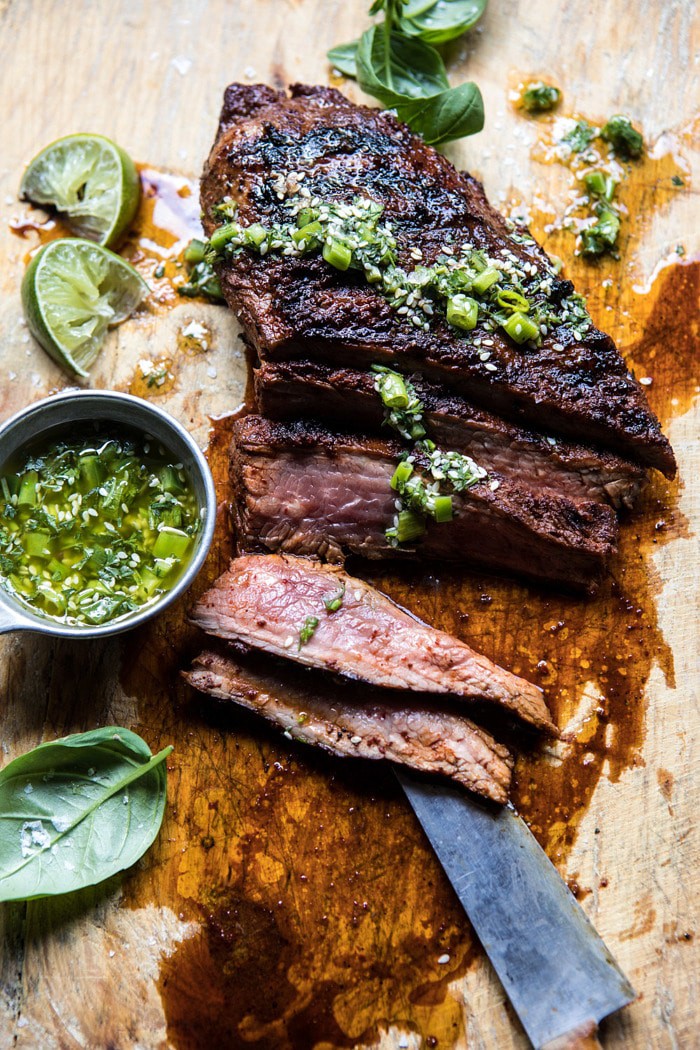 overhead photo of Korean Grilled Steak with Toasted Sesame Chimichurri with slices of steak missing