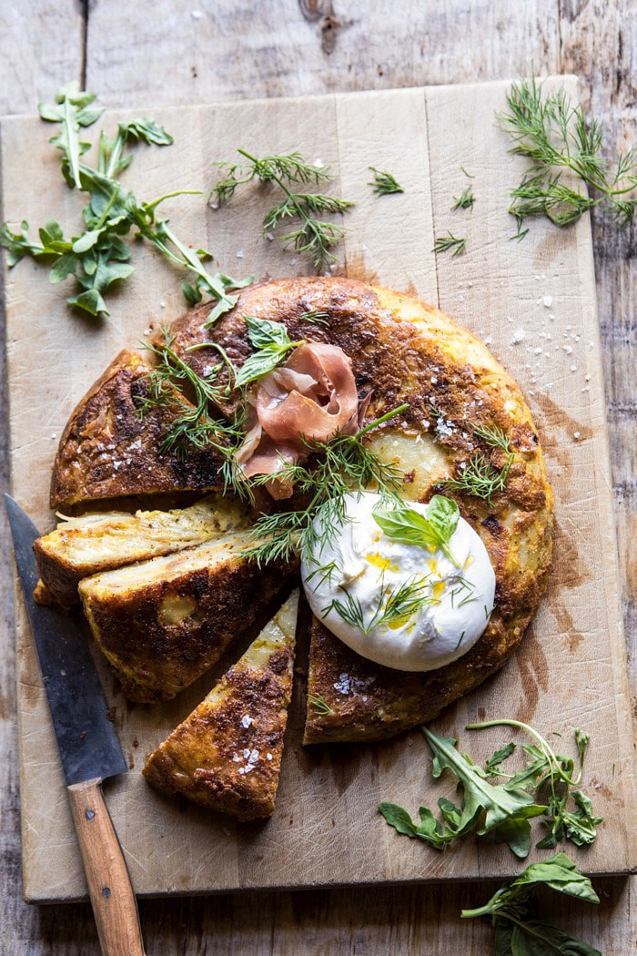 overhead photo of Spanish Tortilla with Burrata and Herbs with knife in photo 