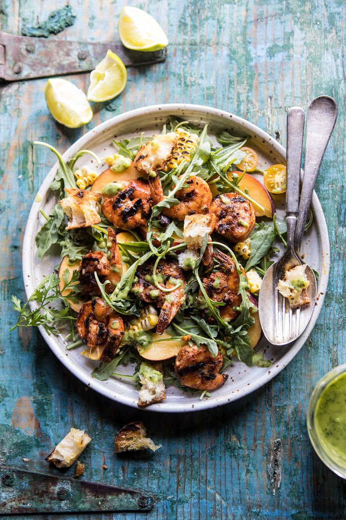 overhead photo of Zesty Grilled Shrimp, Bread and Sweet Peach Salad with Avocado Vinaigrette and limes in photo