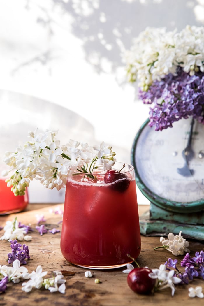 front on, far back photo of Hibiscus Cherry Vodka Spritz with lilacs