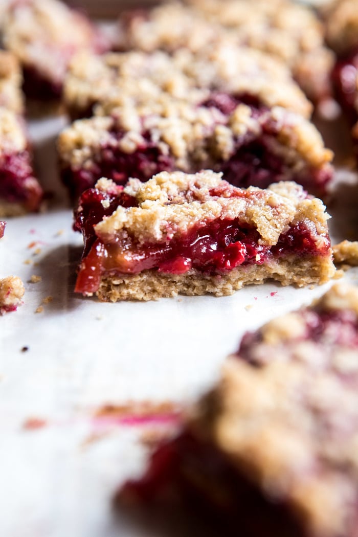 close up photo of Buttery Raspberry Crumble Bar broken in half to show the filling