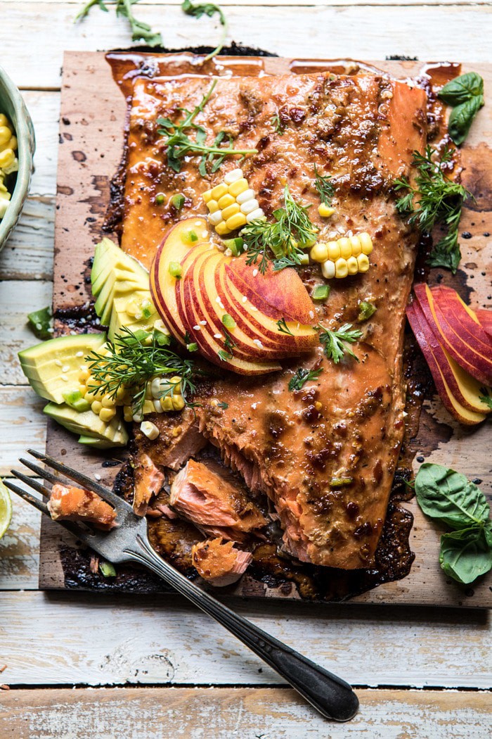 overhead photo of Honey Ginger Cedar Plank Grilled Salmon with Avocado Salsa and fork in photo with salmon