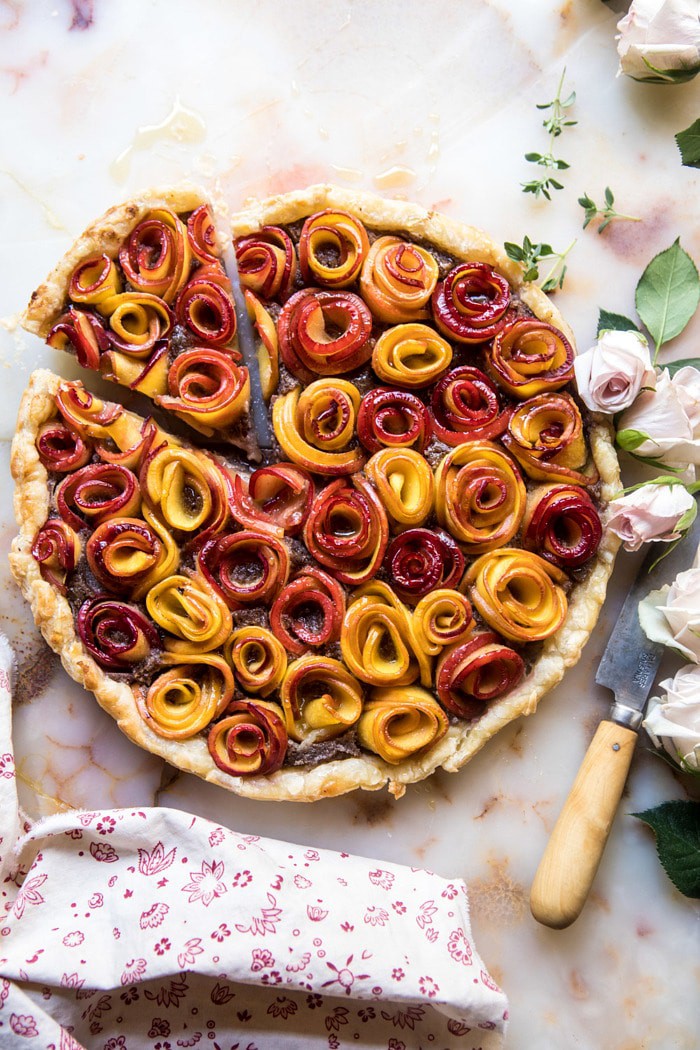 overhead photo of Sweet Peach Rose Tart with 1 piece cut, knife, and roses in photo