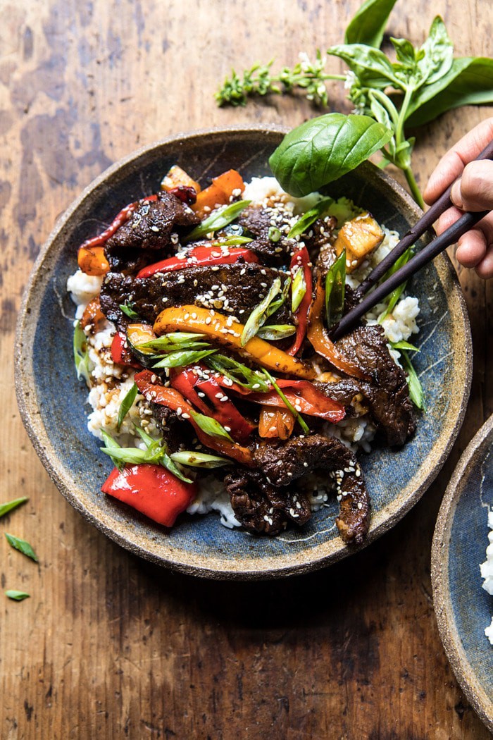 overhead photo of 30 Minute Korean Beef and Peppers with Sesame Rice with hands in photo 