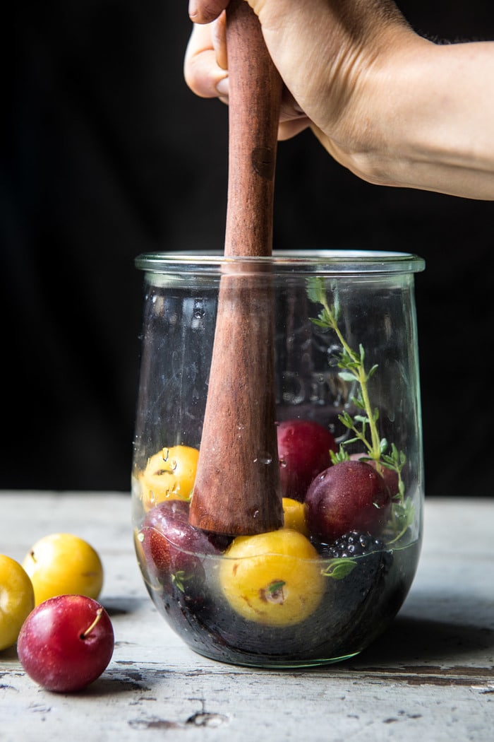 mashing blackberries and plums with muddler