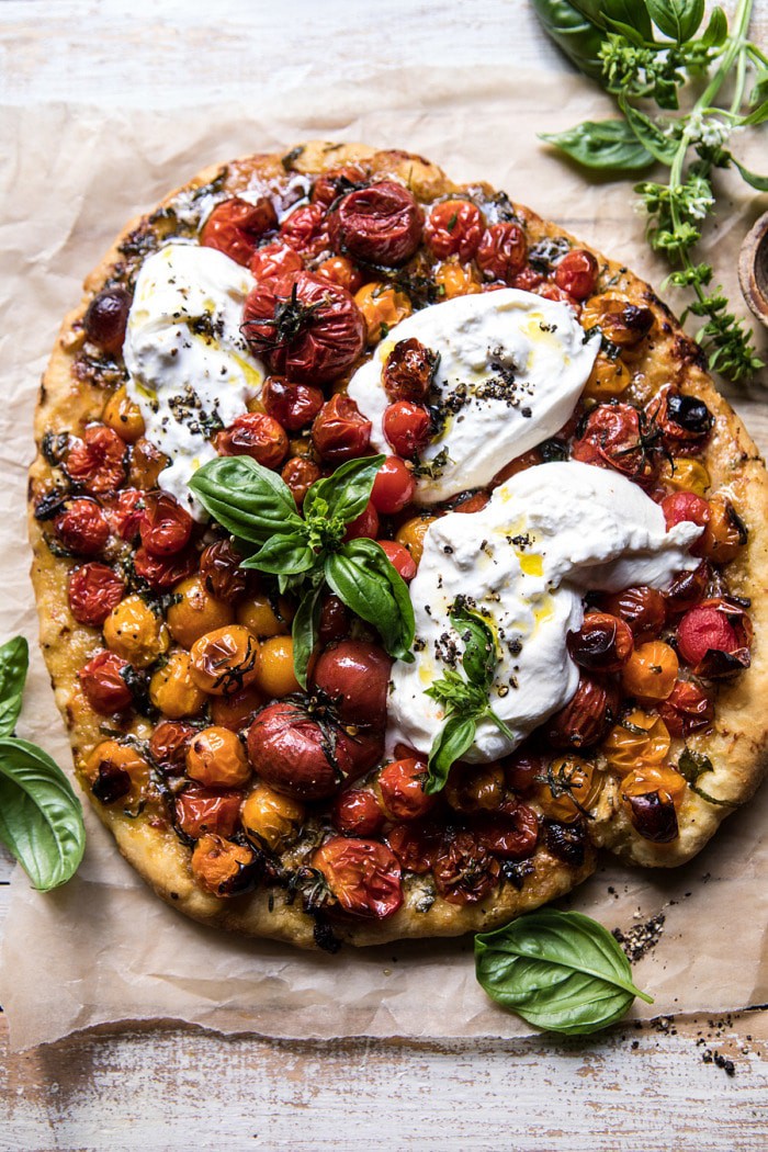 overhead photo of Garlic and Herb Roasted Cherry Tomato Pizza with Caramelized Onions with fresh basil in photo 
