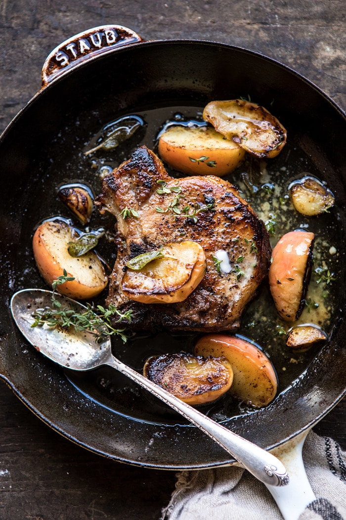 overhead photo of Apple Butter and Sage Pork Chops in skillet with apples and spoon