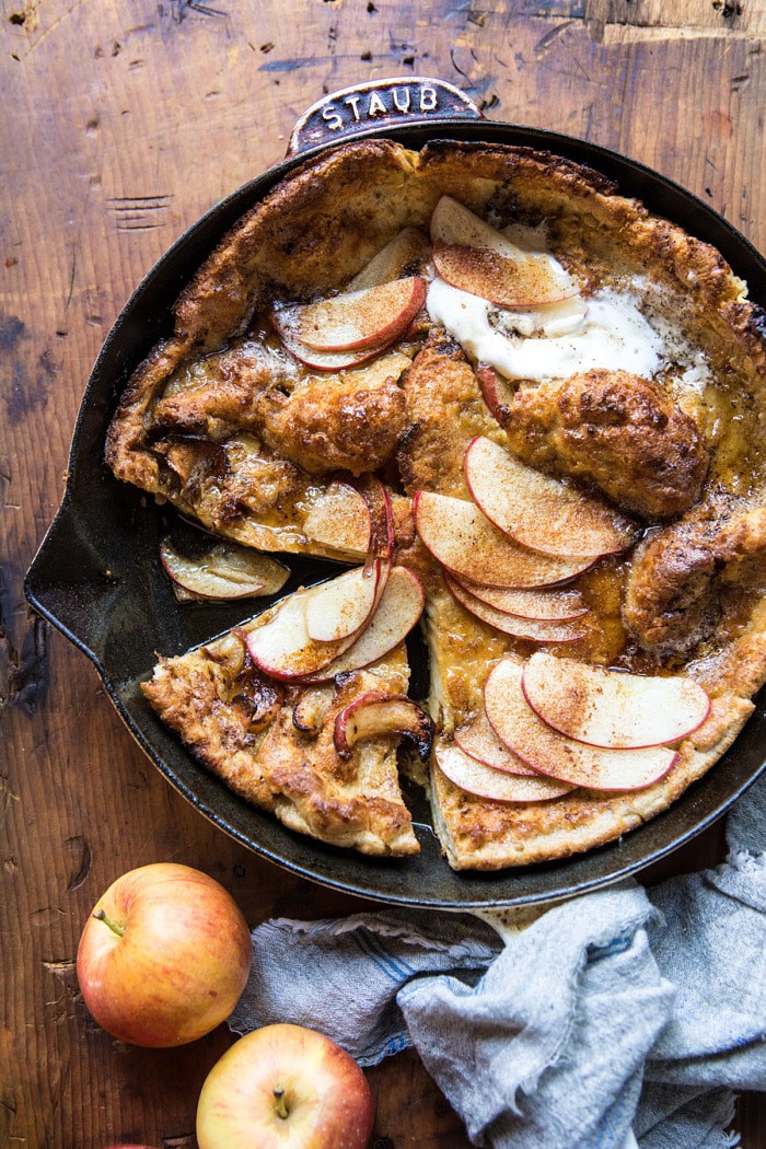 overhead photo of Cinnamon Apple Puffed Pancake in skillet with pieces cut out
