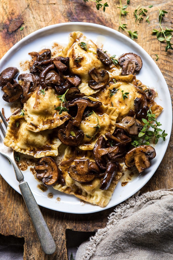 overhead, close up photo of Herby Buttered Balsamic Mushroom Ravioli on plate with fork