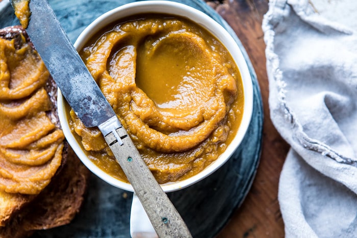 horizontal overhead photo of 6 Ingredient Spiced Pumpkin Butter with butter knife on bowl