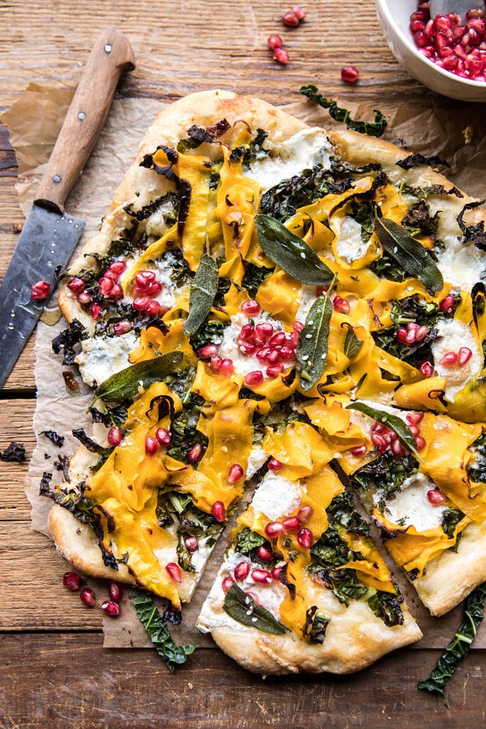 overhead photo of Caramelized Onion, Butternut Squash, and Crispy Kale Pizza with piece cute out 