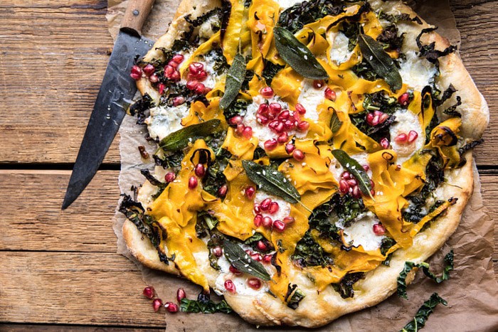 horizontal photo of Caramelized Onion, Butternut Squash, and Crispy Kale Pizza with knife in photo 