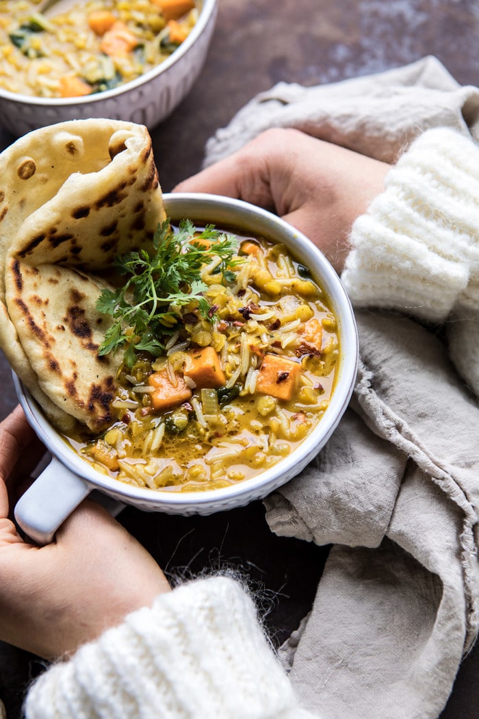 Coconut Sweet Potato Lentil Soup with Rice with hands on bowl 