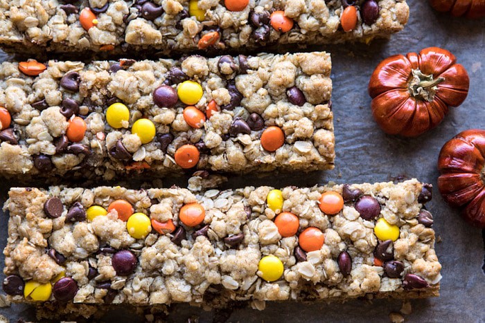 horizontal photo of Monster Oatmeal Chocolate Chip Cookie Bars with mini pumpkins in photo