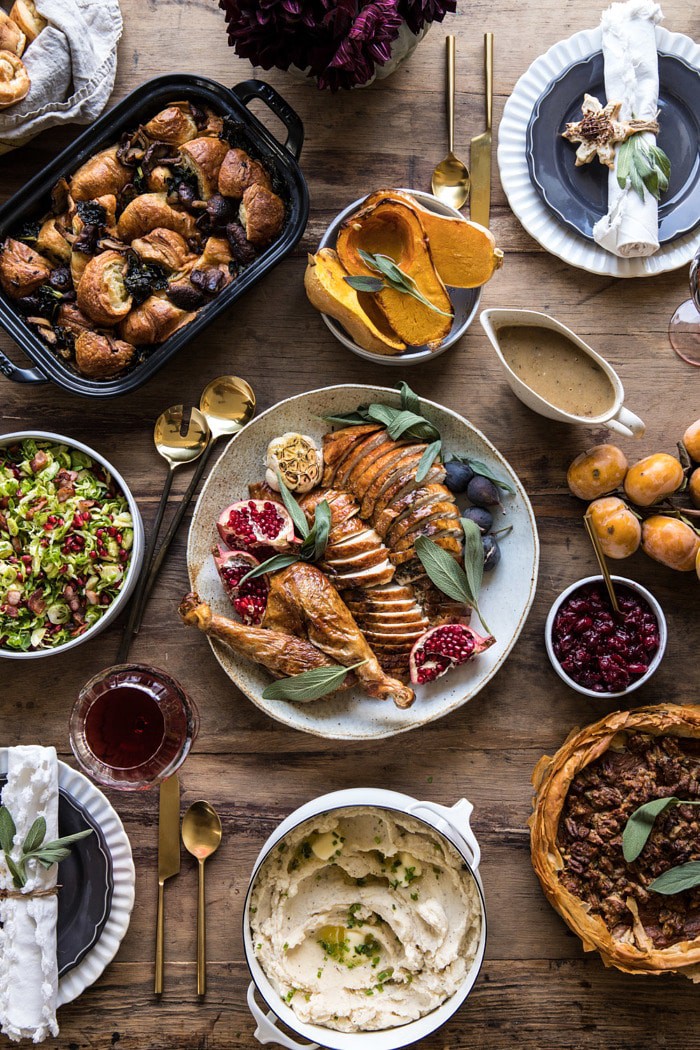 overhead photo of Thanksgiving table with turkey, potatoes, stuffing, and flowers
