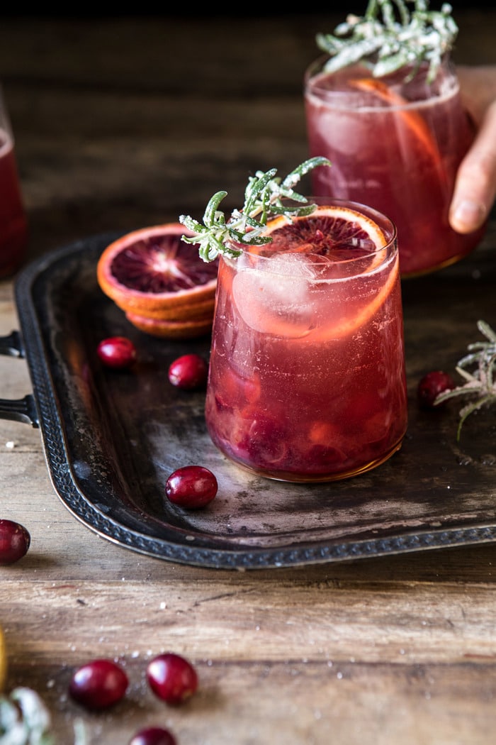 side angle photo of Spiced Cranberry Rosé Spritzers with hand grabbing drink