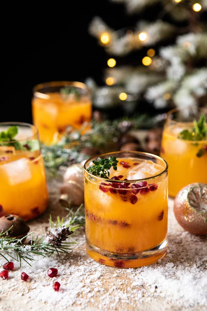 3/4 angled photo of Holy Jolly Christmas Citrus Cocktail with tree in background