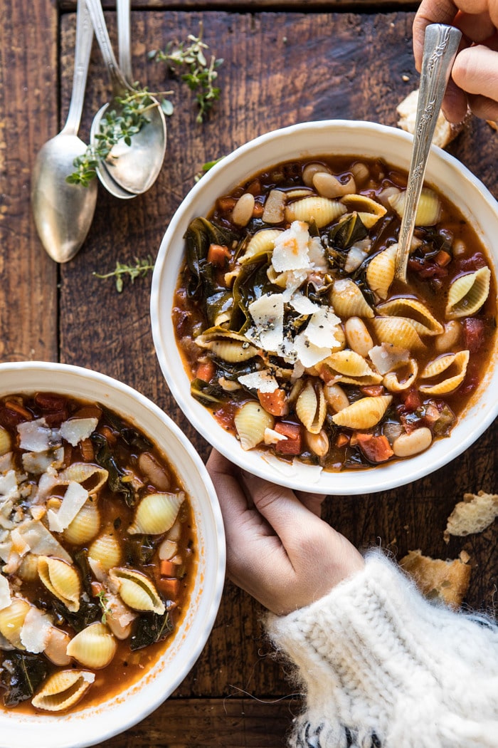 overhead photo of Instant Pot Pasta e Fagioli with hands on bowl