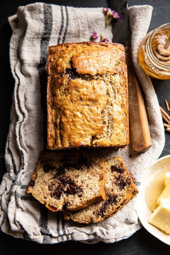 Chocolate Chunk Coconut Banana Bread with 2 pieces cut and honey in photo