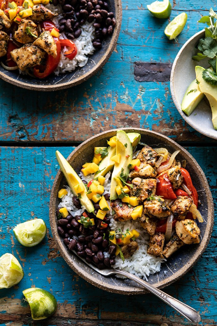overhead photo of Sheet Pan Cuban Chicken and Black Bean Rice Bowl and avocado and limes on surface