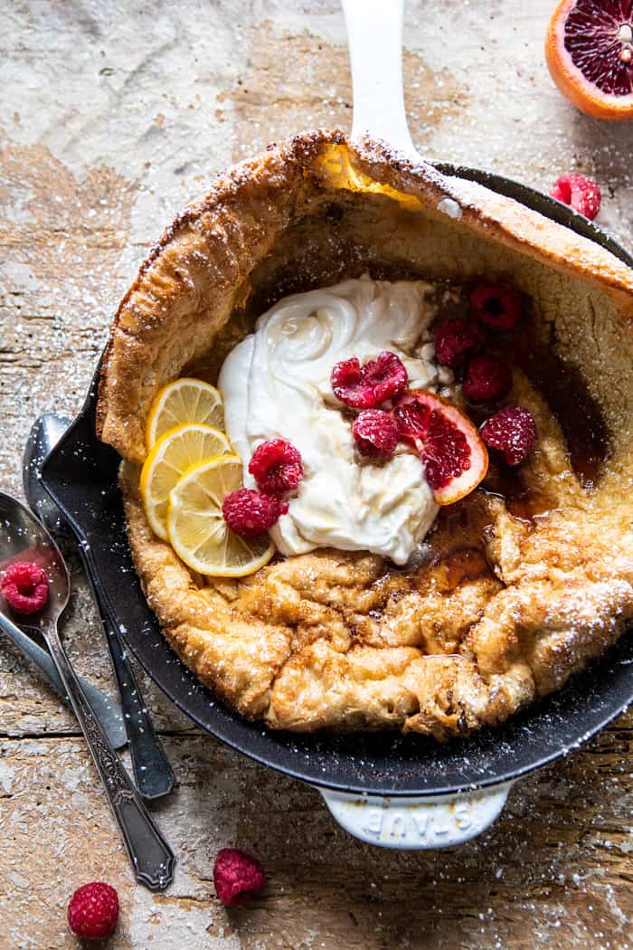 overhead close up photo of Whole Wheat Dutch Baby in skillet with Meyer Lemon Whipped Ricotta and berries
