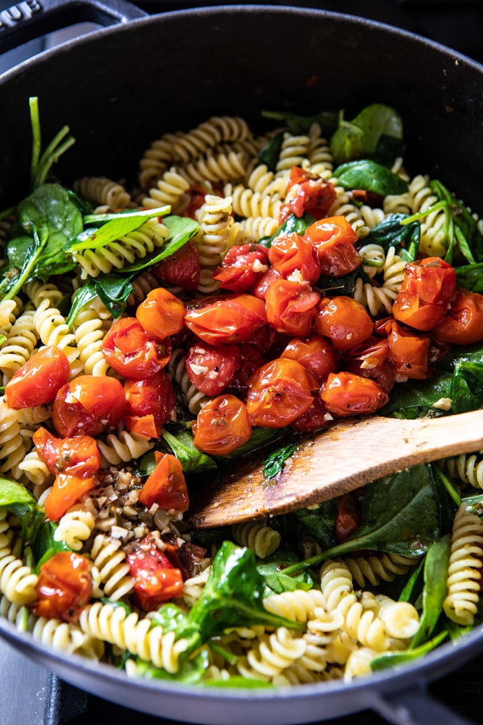 Caprese Pesto Pasta being tossed together in bowl