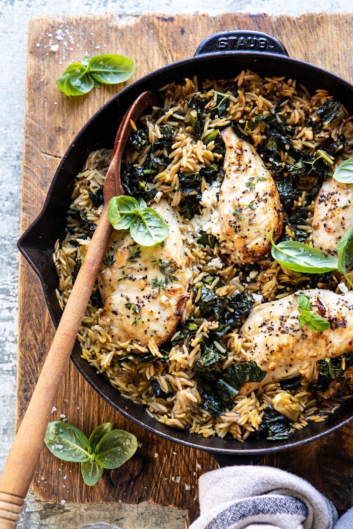 overhead photo of One Skillet Goat Cheese Stuffed Chicken and Orzo with spoon in skillet