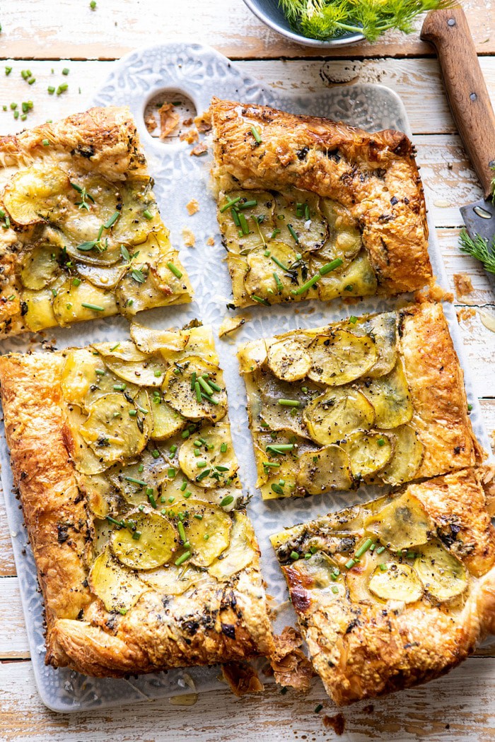 overhead photo of Cheesy Potato Chive Galette with slices cut