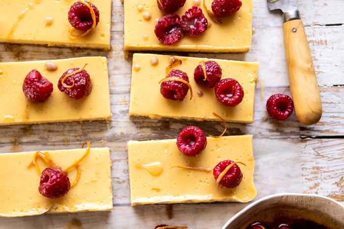 horizontal photo of Creamy Lemon Bars with Browned Butter Raspberries 