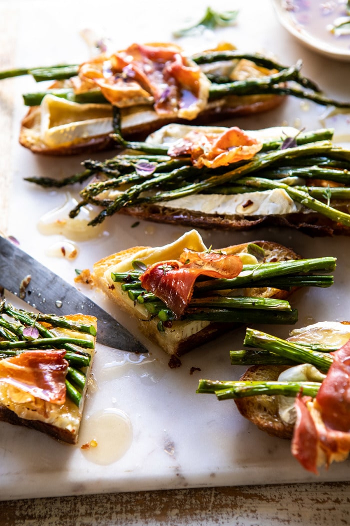 side angled photo of Crispy Prosciutto, Asparagus, and Brie Toast cut in half