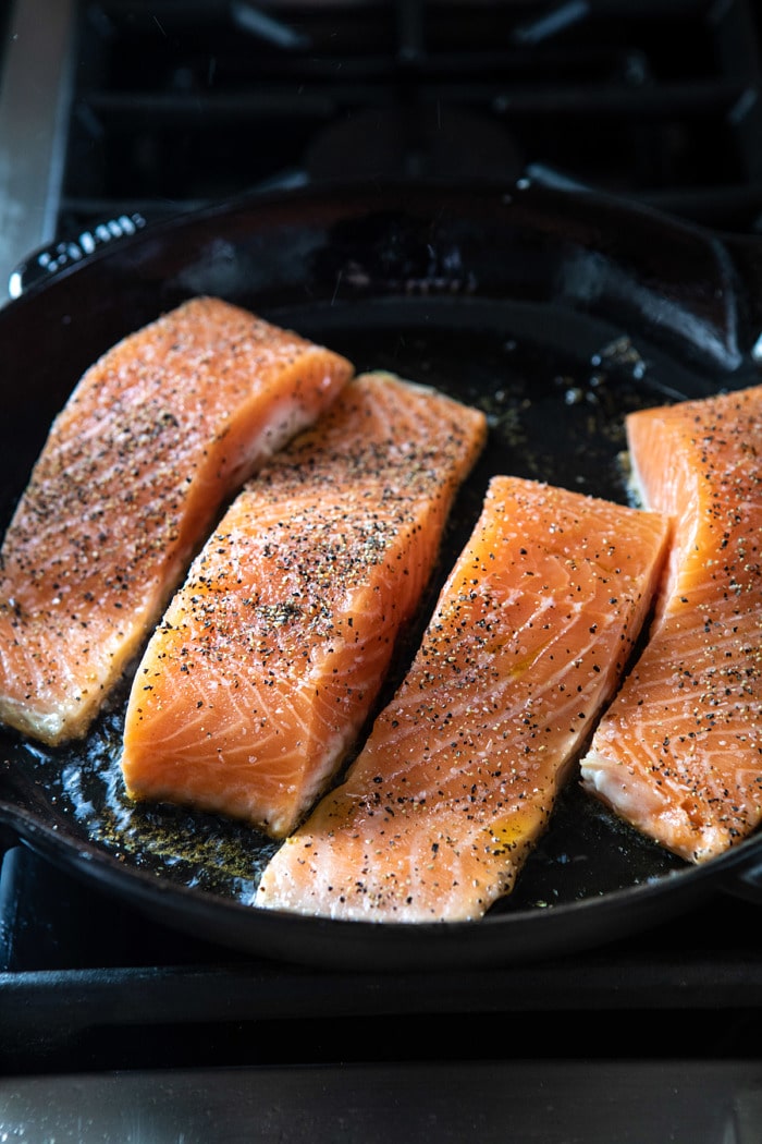 raw salmon cooking in skillet 