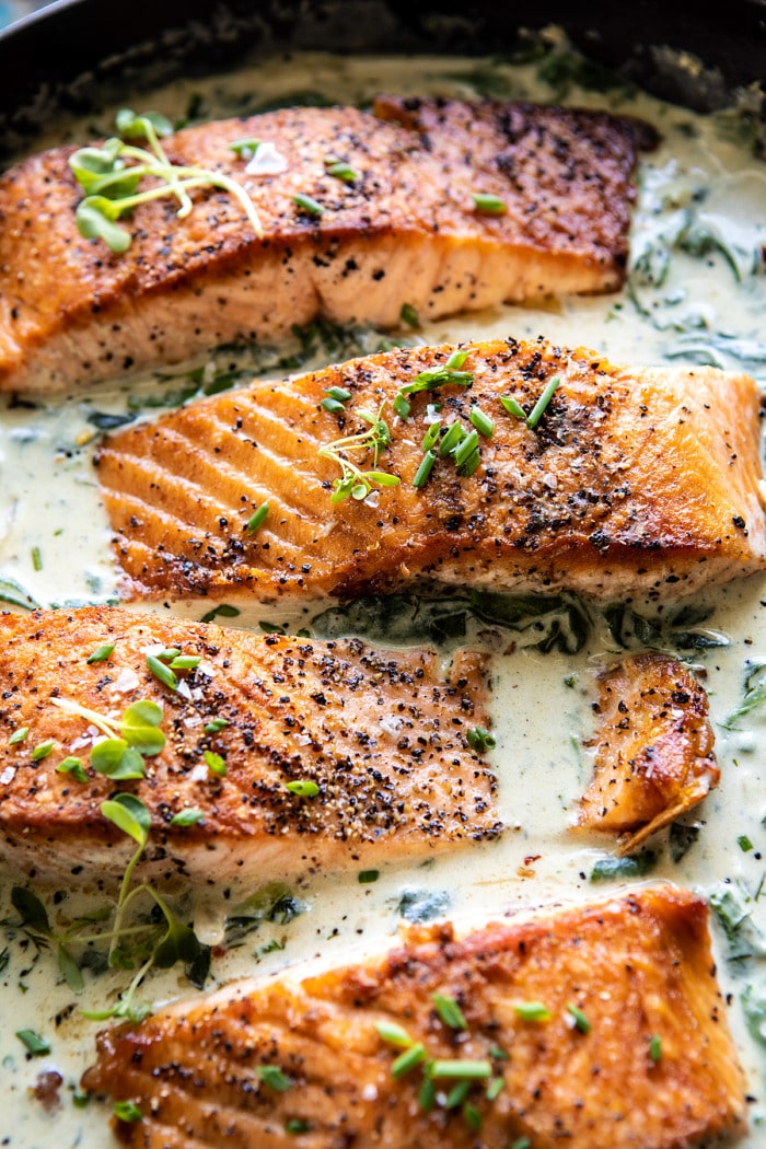 side angled close up photo of Garlic Butter Creamed Spinach Salmon in skillet 