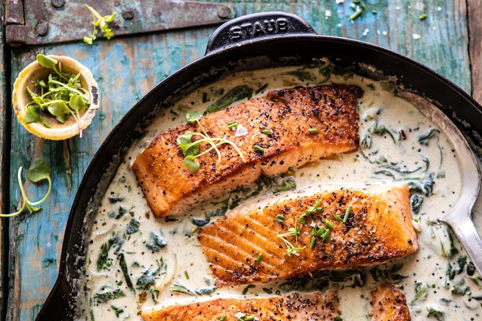 horizontal photo of Garlic Butter Creamed Spinach Salmon in skillet