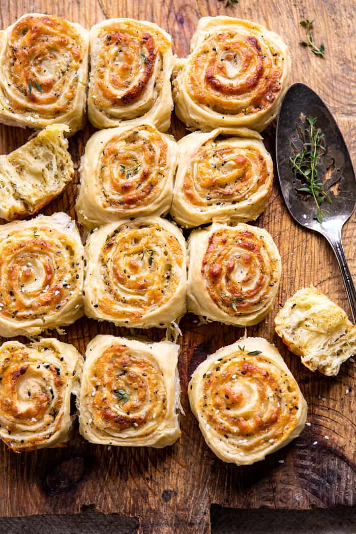overhead Herby Everything Cheddar Swirl Buns with serving spoon and herbs 