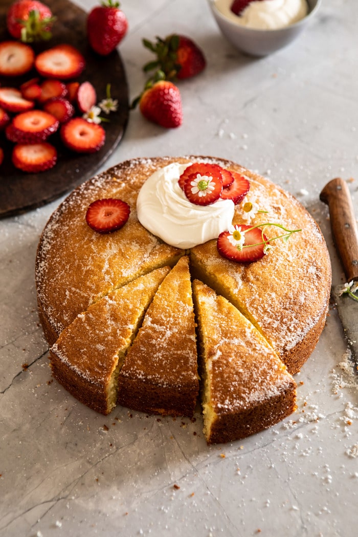 side angled photo of Strawberry Chamomile Olive Oil Cake with Honeyed Ricotta and 3 slices cut