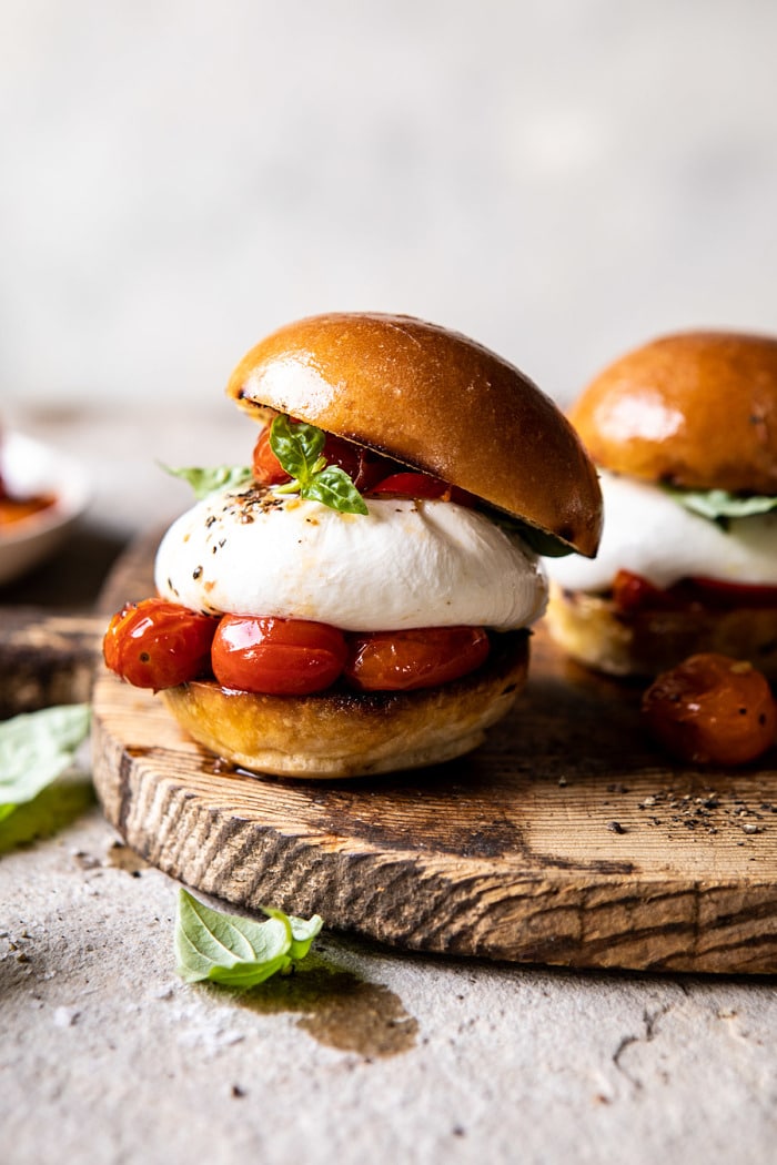 front on photo of Roasted Caprese Burrata Sliders on cutting board