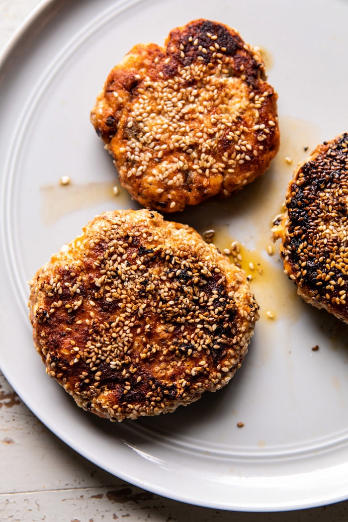 overhead close up photo of Sesame Crusted Curried Salmon Burgers on plate