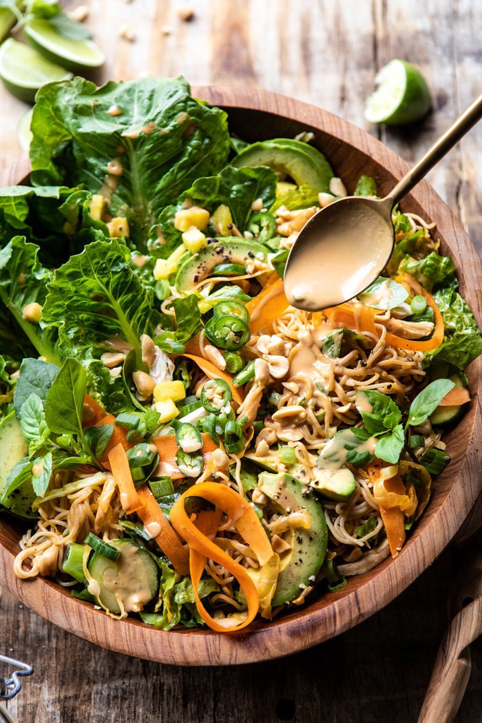 Thai Peanut Chicken Ramen Noodle Salad with spoon drizzling on peanut sauce
