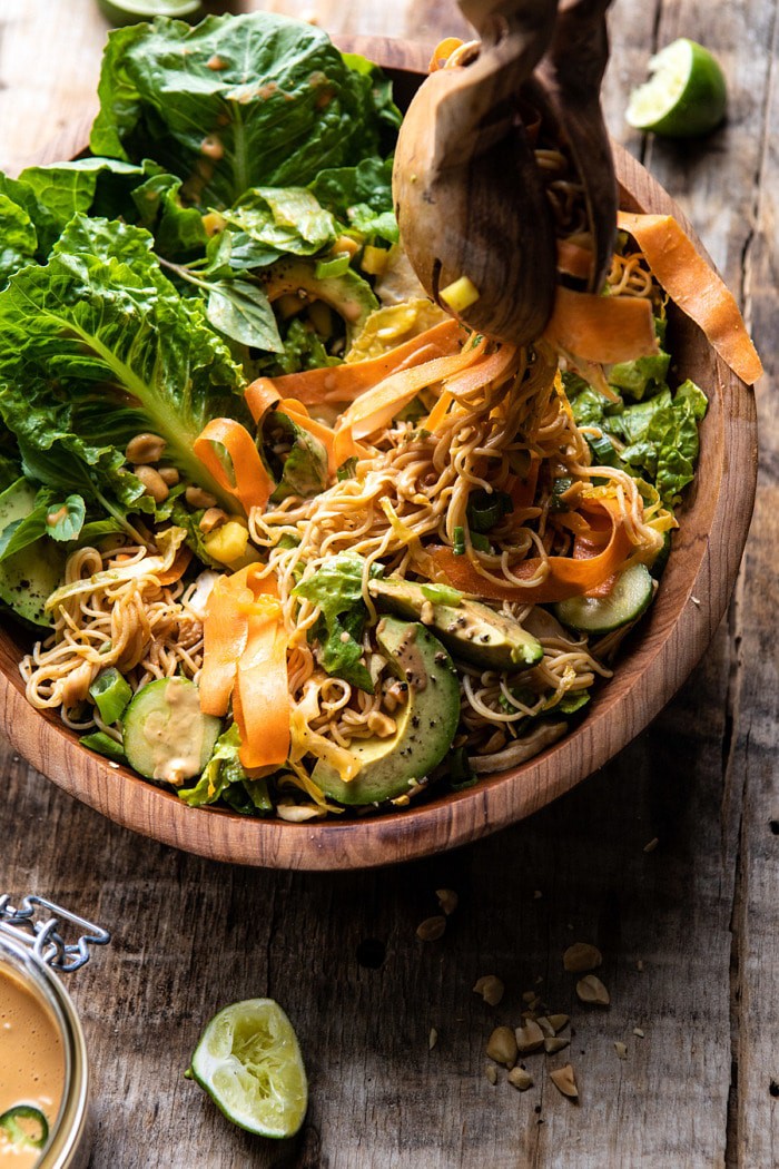 Thai Peanut Chicken Ramen Noodle Salad with tongs pulling up noodles out of bowl