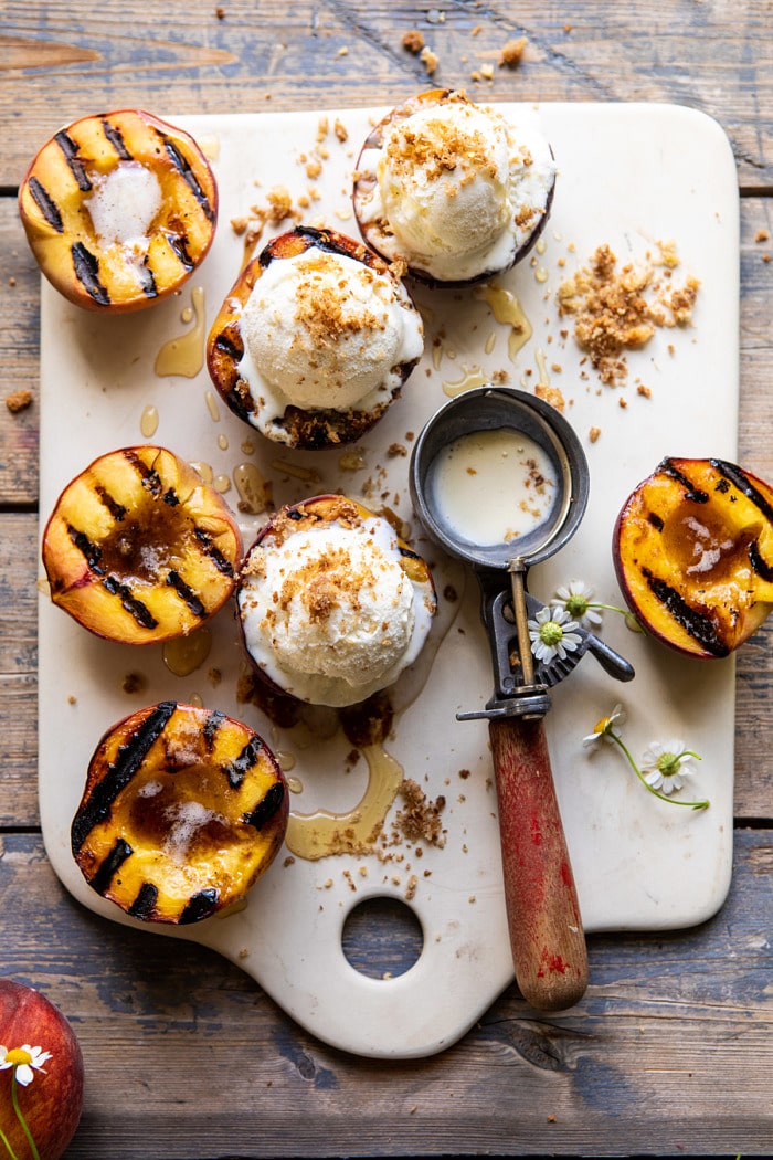 overhead photo of Browned Butter Grilled Peaches with Cinnamon Toast Brioche Crumbs on serving plate with ice cream scoop