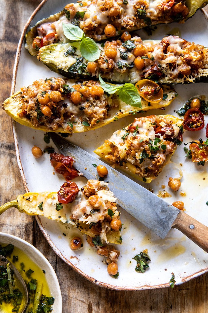overhead photo of Spicy Chickpea and Cheese Stuffed Zucchini with zucchini cut in half and filling spilling out